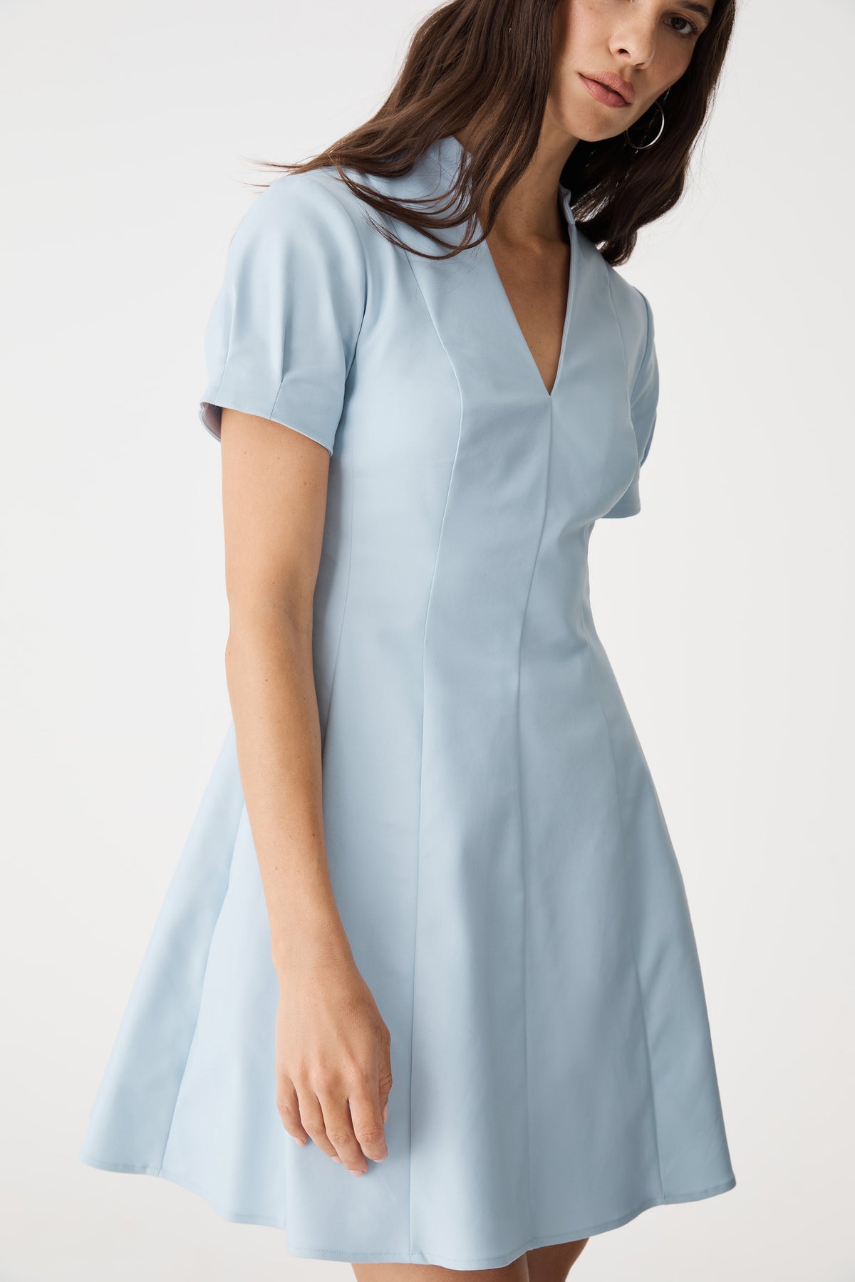 Close-up of collar, V-neckline and pleated sleeve cuff
