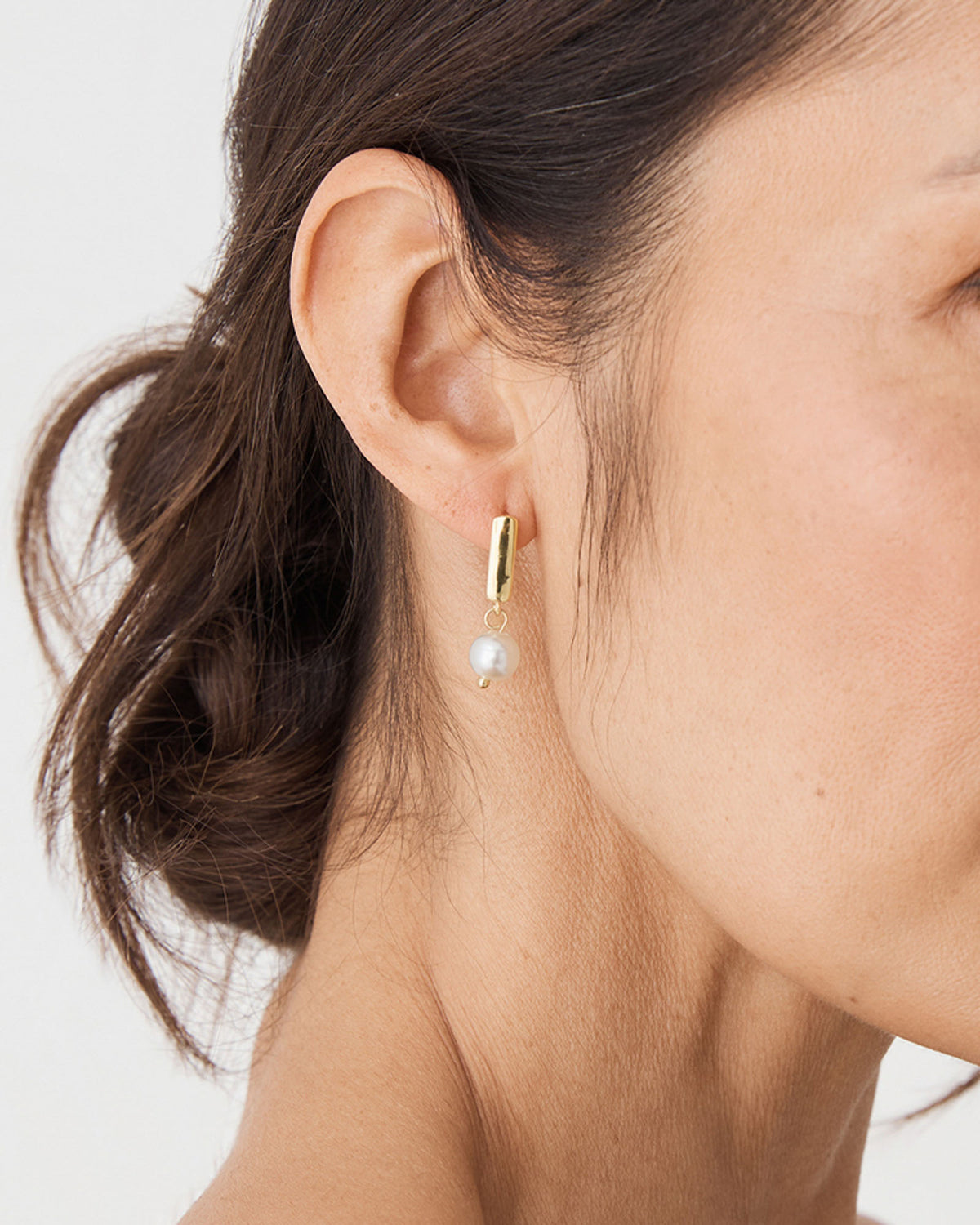 Mila Pearl Huggie Earrings in gold pearl — fabric detail 3